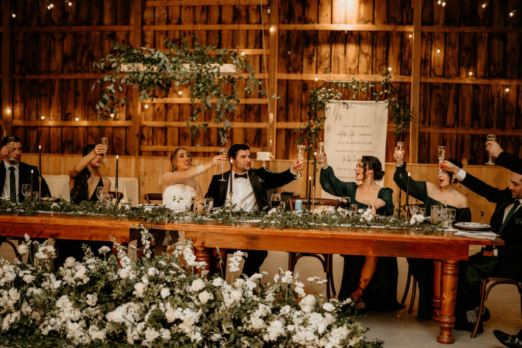 Green, black, and ivory head table decor at Catskills wedding reception