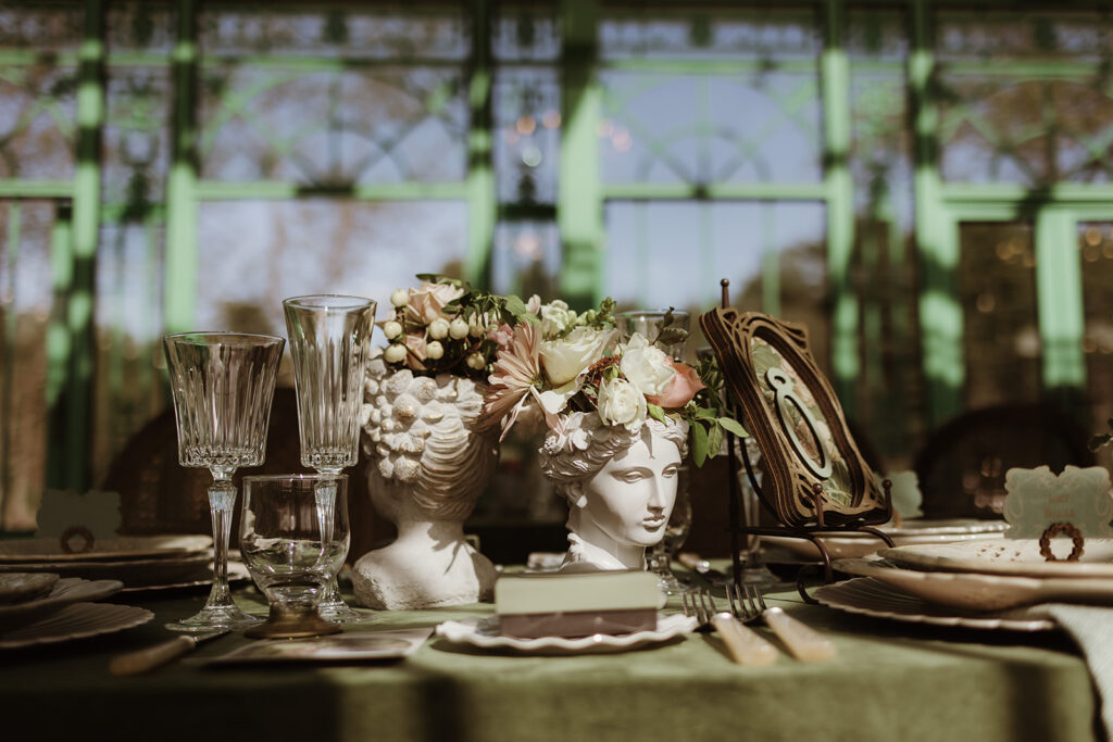 Neo-classical busts holding Garden-style wedding centerpieces at L'Orangerie wedding venue in NY