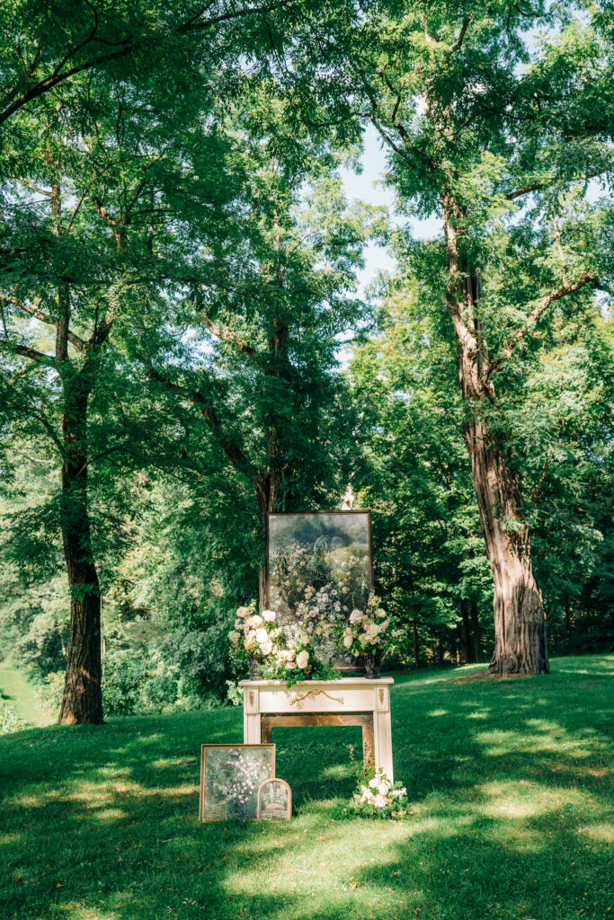 Antique mantel in tree allee with floating ‘Wild Roses’ painting and cascading florals